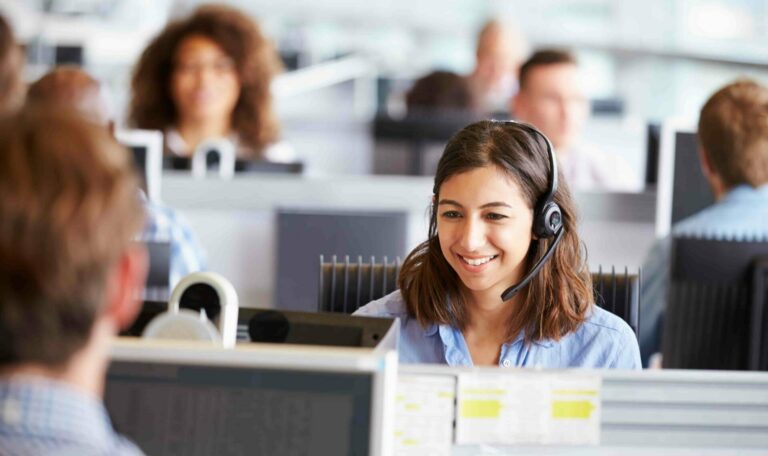 Eine Frau mit Headset sitzt bei der Arbeit in einem Call-Center