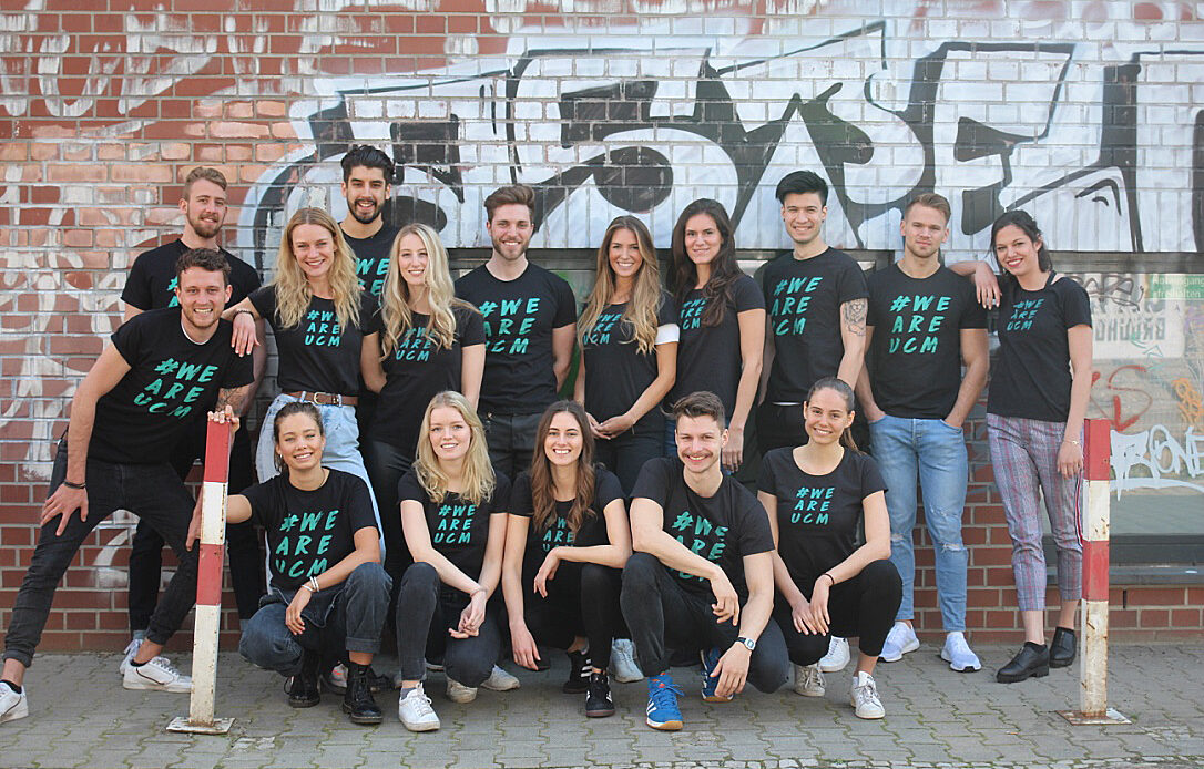 Große Gruppe von ucm Studierenden vor einer Mauer