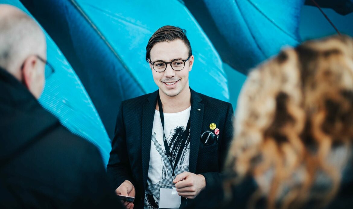 Host auf einer Messe mit Lanyard und Sakko