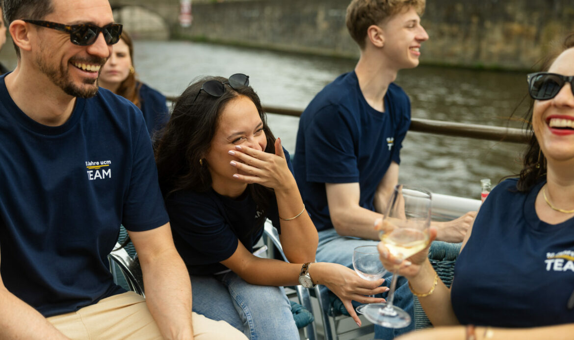 Lachendes Team von ucm auf einem Boot