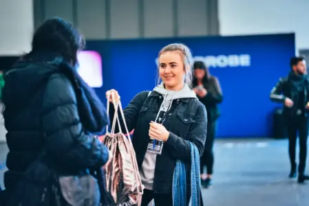 Junge Frau übergibt einer Person ihren Beutel