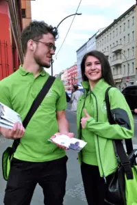 Ein Mann und eine Frau in grüner Kleidung promoten eine Brand auf der Straße